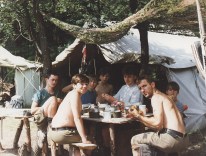 Czarni na śniadaniu przy swoich namiotach 